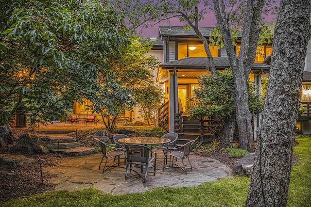 2002 Valleyview Dr, Ann Arbor, MI 48105 - back of property at dusk with a patio area and roof with shingles