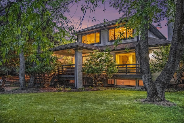 2002 Valleyview Dr, Ann Arbor, MI 48105 - back of property at dusk featuring a lawn and a shingled roof