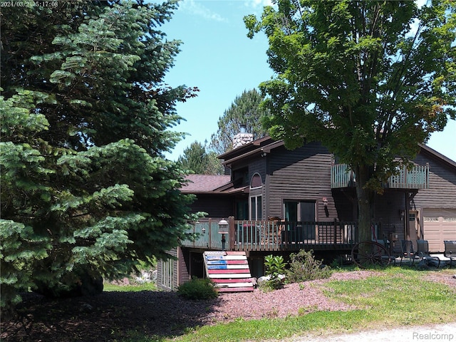 6140 Mcguire Rd, Fenton, MI 48430 - view of front of house featuring a wooden deck, a garage, a chimney, and stairs