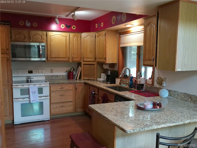 6140 Mcguire Rd, Fenton, MI 48430 - kitchen featuring stainless steel microwave, range with two ovens, track lighting, a peninsula, and wood finished floors
