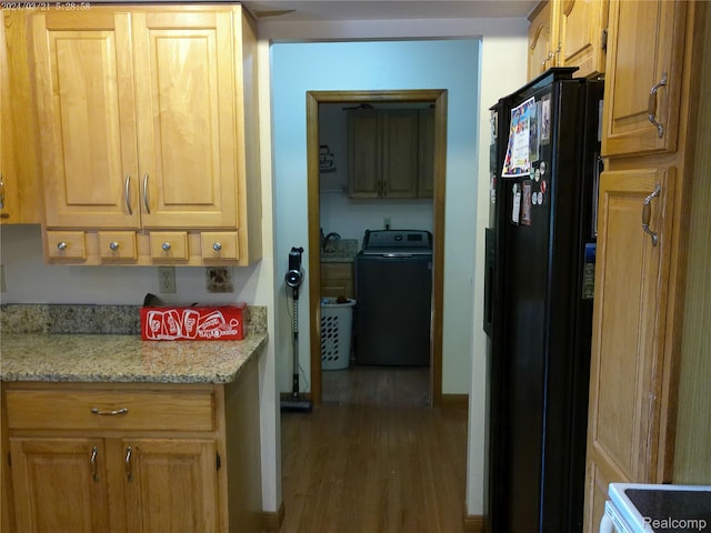 6140 Mcguire Rd, Fenton, MI 48430 - kitchen featuring washer / clothes dryer, black fridge, wood finished floors, and light stone countertops