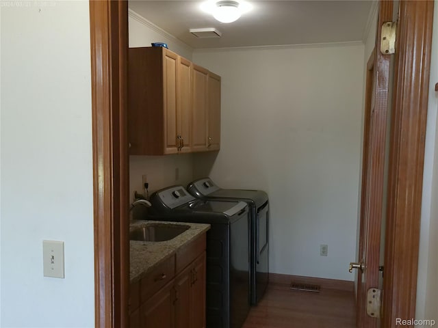 6140 Mcguire Rd, Fenton, MI 48430 - laundry room featuring cabinet space, washing machine and clothes dryer, ornamental molding, and wood finished floors
