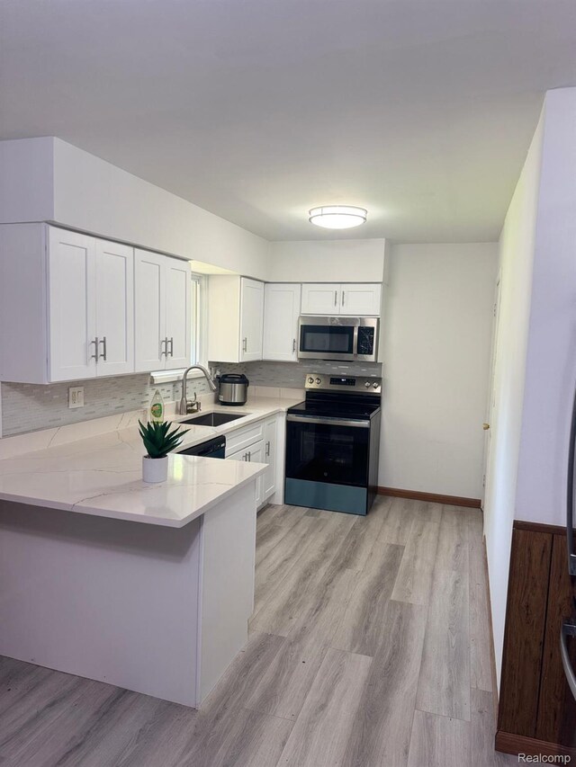21451 N Nunneley Rd, Shelby Twp, MI 48036 - kitchen with stainless steel appliances, a sink, white cabinets, a peninsula, and tasteful backsplash