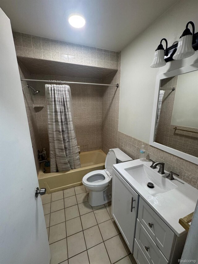 21451 N Nunneley Rd, Shelby Twp, MI 48036 - bathroom featuring shower / bath combo with shower curtain, tile patterned floors, toilet, vanity, and tile walls