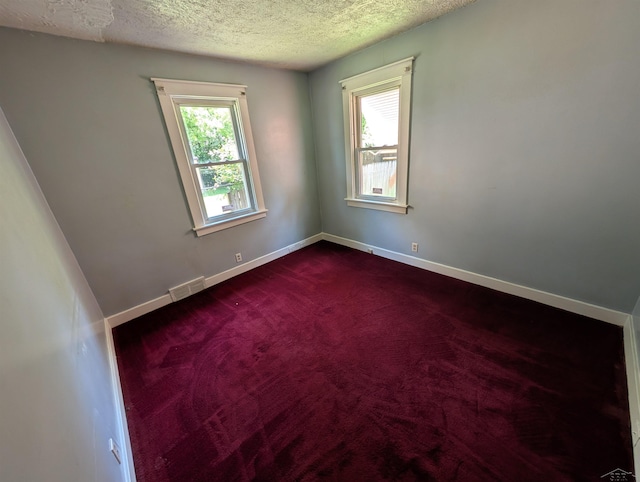 1712 S Hamilton St, Saginaw, MI 48602 - empty room with a textured ceiling, baseboards, and dark colored carpet