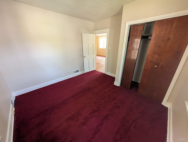 1712 S Hamilton St, Saginaw, MI 48602 - unfurnished bedroom featuring dark colored carpet, a textured ceiling, a closet, and baseboards