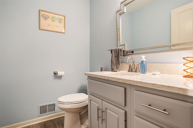 3225 Bronson Blvd, Kalamazoo, MI 49008 - half bathroom featuring vanity, toilet, wood finished floors, and baseboards