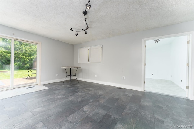 3260 Van Campen Dr, Waterford, MI 48329 - spare room with track lighting, a textured ceiling, and baseboards