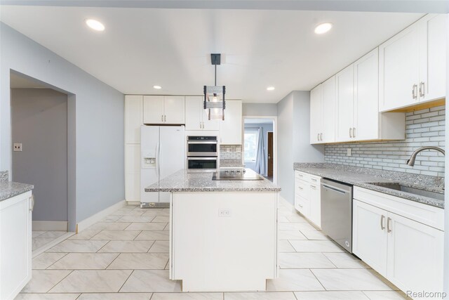 3260 Van Campen Dr, Waterford, MI 48329 - kitchen featuring stainless steel appliances, a sink, tasteful backsplash, a center island, and white cabinets