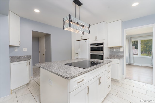 3260 Van Campen Dr, Waterford, MI 48329 - kitchen with black electric cooktop, double oven, white refrigerator with ice dispenser, white cabinets, and light stone countertops