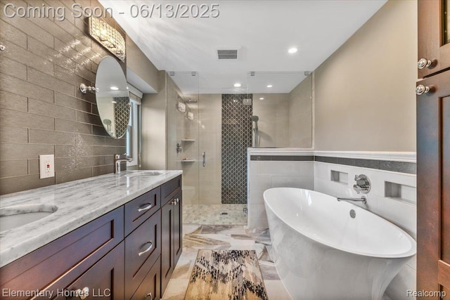 2456 Red Maple Dr, Troy, MI 48098 - bathroom featuring a stall shower, double vanity, a freestanding tub, tile walls, and recessed lighting