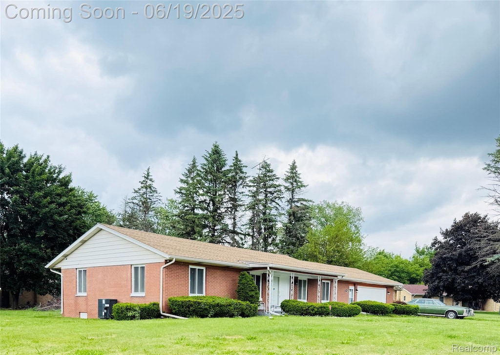 5095 Camborne Ct, Flint, MI 48504 - ranch-style house with brick siding, a front lawn, and an attached garage