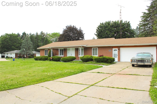 5095 Camborne Ct, Flint, MI 48504 - ranch-style home with an attached garage, concrete driveway, a front lawn, and brick siding