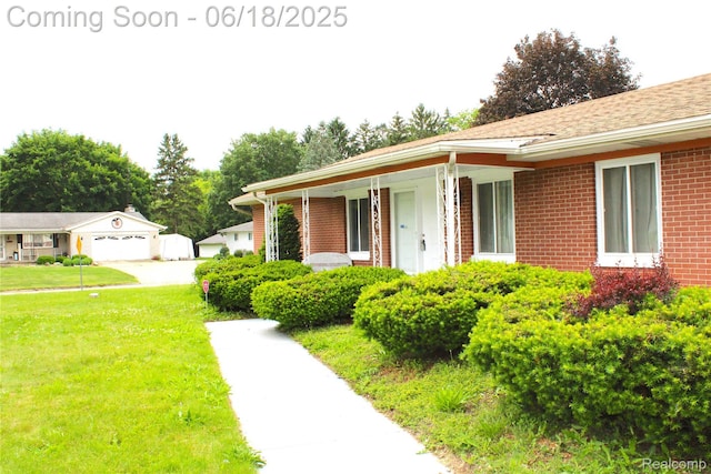 5095 Camborne Ct, Flint, MI 48504 - view of front of property with brick siding, a front lawn, a porch, and a garage