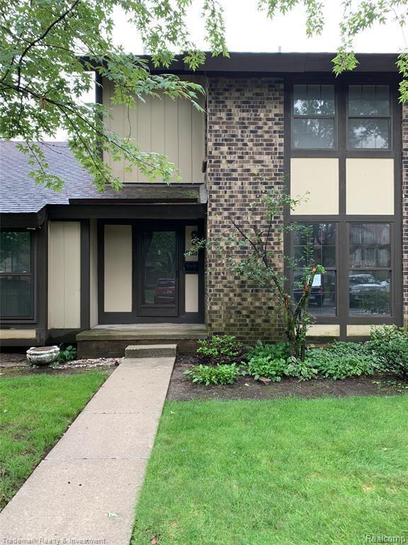 25045 Glenbrooke Dr, Southfield, MI 48033 - entrance to property featuring a yard, brick siding, and roof with shingles