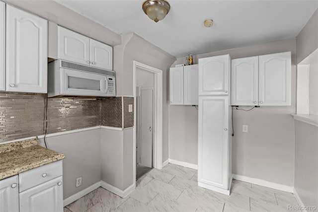 11603 Lansdowne St, Detroit, MI 48224 - kitchen with white microwave, white cabinetry, and light marble finish floors