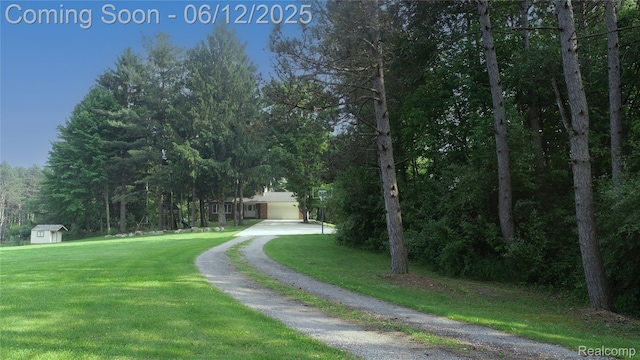 5836 Ewalt Rd, Imlay City, MI 48444 - view of property's community featuring a yard, driveway, a storage unit, and a garage