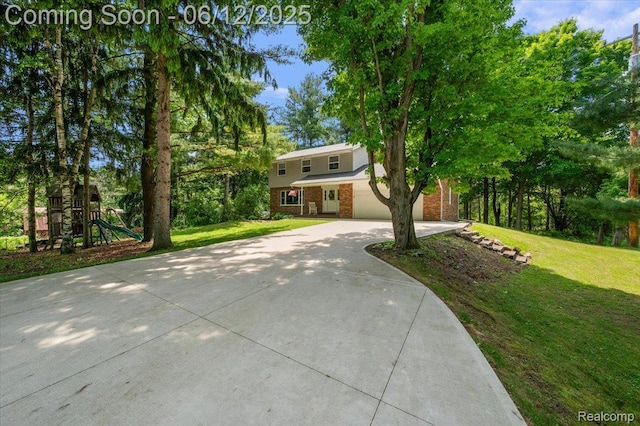 5836 Ewalt Rd, Imlay City, MI 48444 - view of front of home featuring concrete driveway, brick siding, a front yard, and a playground