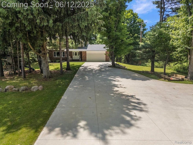 5836 Ewalt Rd, Imlay City, MI 48444 - view of front of property with driveway, brick siding, an attached garage, and a front lawn