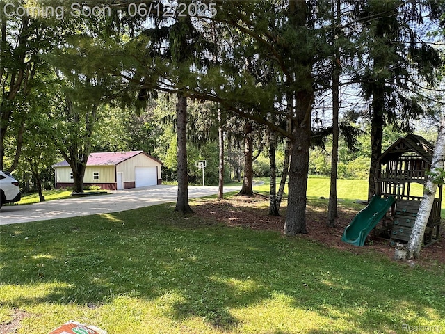 5836 Ewalt Rd, Imlay City, MI 48444 - view of grassy yard featuring a playground, a garage, driveway, and an outbuilding