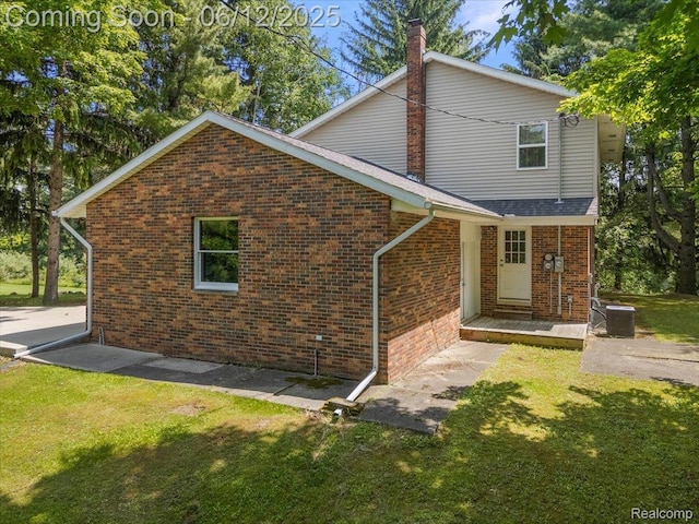 5836 Ewalt Rd, Imlay City, MI 48444 - view of front of house with a front yard, brick siding, and a chimney