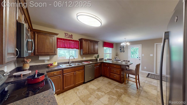 5836 Ewalt Rd, Imlay City, MI 48444 - kitchen featuring appliances with stainless steel finishes, dark countertops, a peninsula, and hanging light fixtures