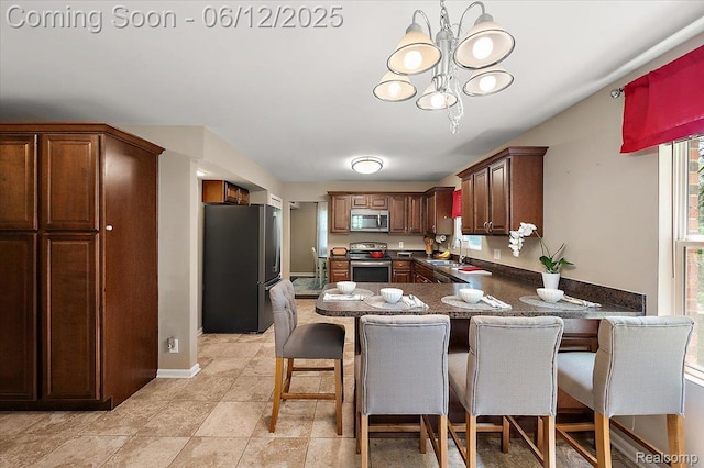 5836 Ewalt Rd, Imlay City, MI 48444 - kitchen featuring stainless steel appliances, a peninsula, a kitchen breakfast bar, and a chandelier