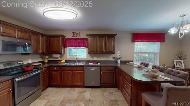 5836 Ewalt Rd, Imlay City, MI 48444 - kitchen featuring appliances with stainless steel finishes, a peninsula, dark countertops, a breakfast bar area, and a chandelier