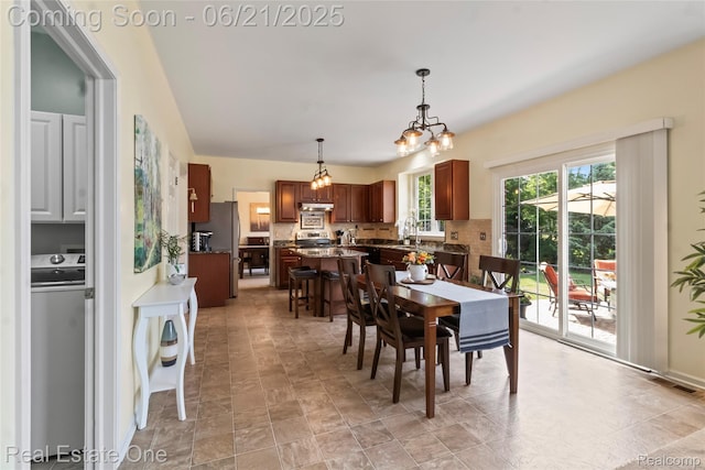 7244 Millrock Ave, Shelby Twp, MI 48317 - dining space with washer / dryer and a chandelier