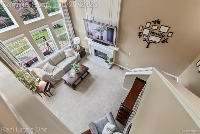 7244 Millrock Ave, Shelby Twp, MI 48317 - living area featuring a towering ceiling, a glass covered fireplace, and carpet