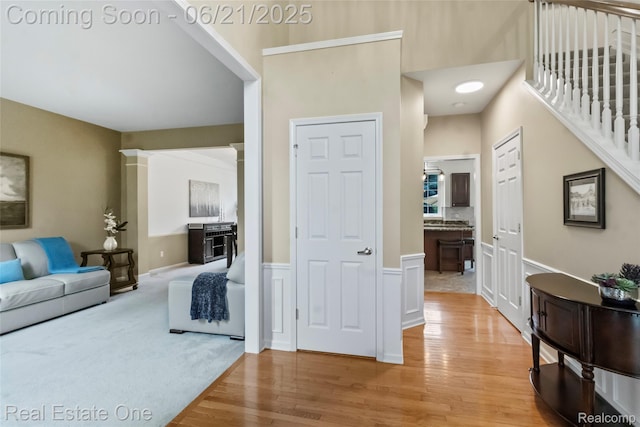 7244 Millrock Ave, Shelby Twp, MI 48317 - living area featuring light wood-style flooring, a wainscoted wall, and stairway