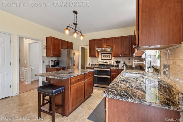 7244 Millrock Ave, Shelby Twp, MI 48317 - kitchen with stainless steel appliances, under cabinet range hood, a kitchen island, decorative backsplash, and dark stone countertops