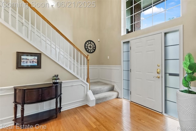7244 Millrock Ave, Shelby Twp, MI 48317 - entryway with stairway, wood finished floors, a wainscoted wall, a decorative wall, and a towering ceiling