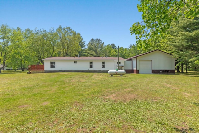 3858 S Chestnut Ave, Newaygo, MI 49337 - back of property featuring a detached garage, a yard, an outdoor structure, and view of wooded area