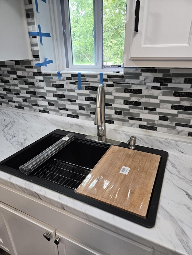 1420 Sweet St, Saginaw, MI 48602 - kitchen view of decorative backsplash, white cabinets, and a sink