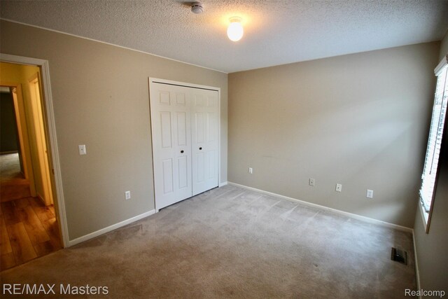 19270 Otto Ct, New Boston, MI 48164 - unfurnished bedroom with carpet, a closet, and a textured ceiling