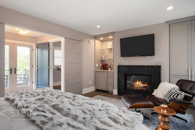 1110 Breton Rd SE, East Grand Rapids, MI 49506 - bedroom with access to exterior, wood finished floors, french doors, recessed lighting, and a premium fireplace