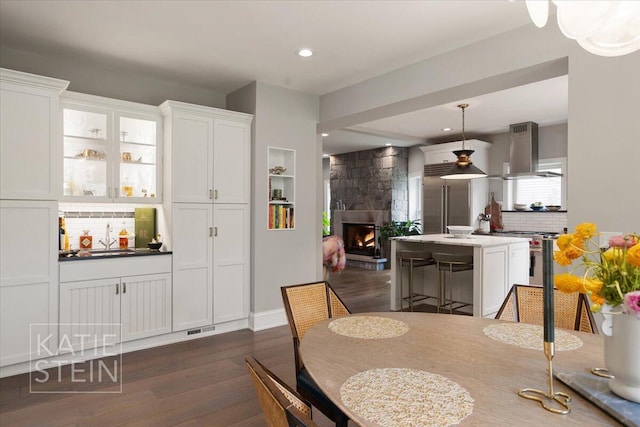 1110 Breton Rd SE, East Grand Rapids, MI 49506 - dining room featuring dark wood-type flooring, a fireplace, and recessed lighting