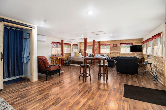 5729 N Bass Lake Rd, Irons, MI 49644 - living area featuring a wall unit AC, wood finished floors, attic access, and recessed lighting