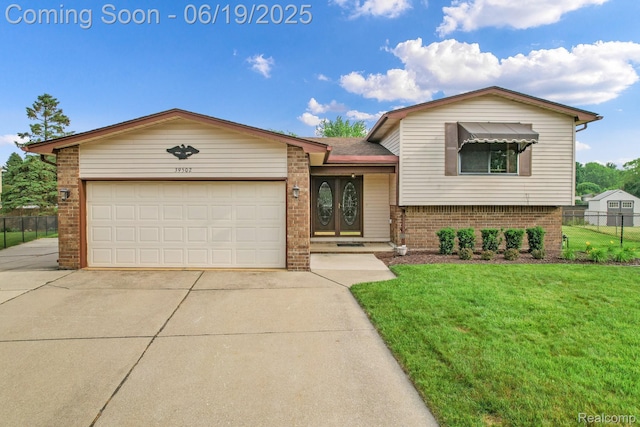 39502 Salvatore Dr, Sterling Heights, MI 48313 - tri-level home with driveway, brick siding, and an attached garage