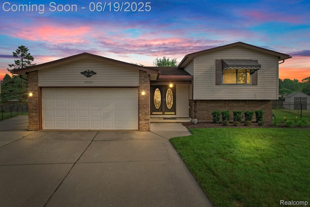 39502 Salvatore Dr, Sterling Heights, MI 48313 - split level home featuring concrete driveway, brick siding, and a garage