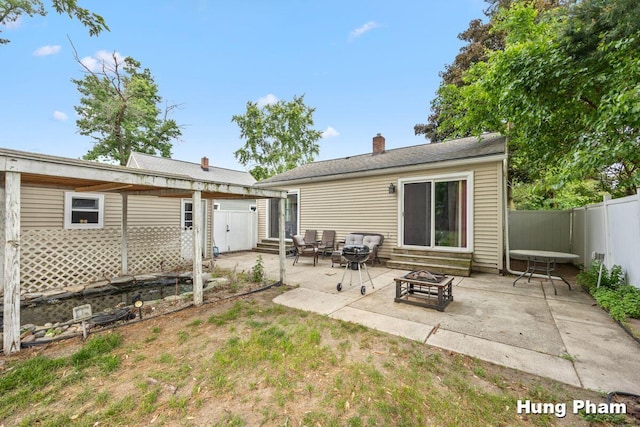 3064 Brookfield Ave NE, Grand Rapids, MI 49505 - back of property with entry steps, an outdoor fire pit, a fenced backyard, a patio area, and a chimney