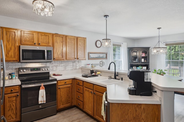 340 E 4th St, Onsted, MI 49265 - kitchen with stainless steel appliances, a chandelier, a peninsula, and plenty of natural light