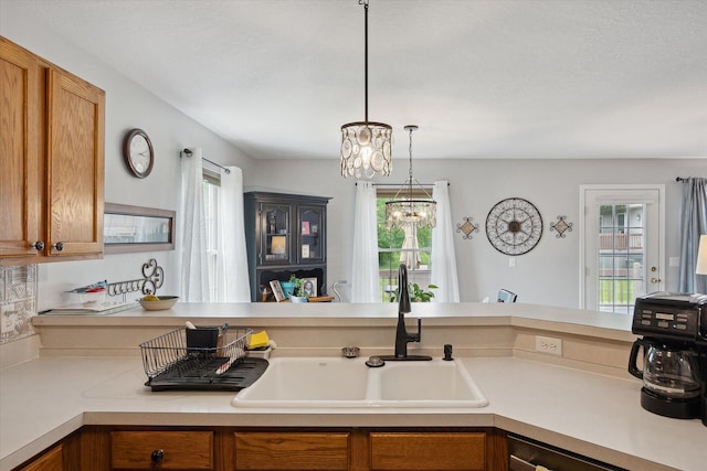 340 E 4th St, Onsted, MI 49265 - kitchen featuring light countertops, brown cabinetry, hanging light fixtures, and a chandelier