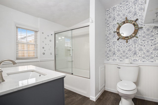 144 E Hickory Rd, Battle Creek, MI 49017 - full bathroom with wood finished floors, bath / shower combo with glass door, vanity, a wainscoted wall, and lofted ceiling