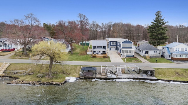 144 E Hickory Rd, Battle Creek, MI 49017 - back of house with a residential view, a lawn, and a water view