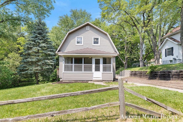 443 Nicholson St, Ionia, MI 48846 - dutch colonial featuring a gambrel roof, a sunroom, a front lawn, and roof with shingles