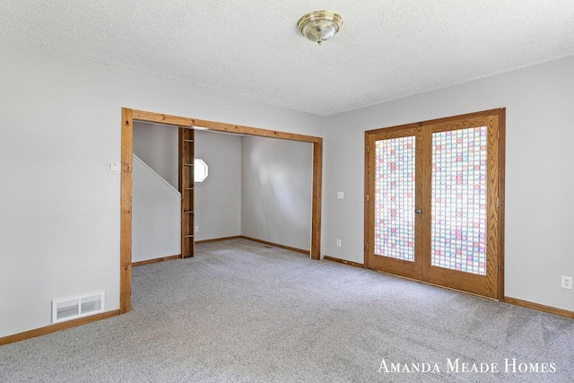 443 Nicholson St, Ionia, MI 48846 - carpeted empty room with a textured ceiling and french doors