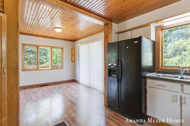 443 Nicholson St, Ionia, MI 48846 - kitchen with black fridge, wood ceiling, white cabinets, dark wood-style flooring, and dark countertops