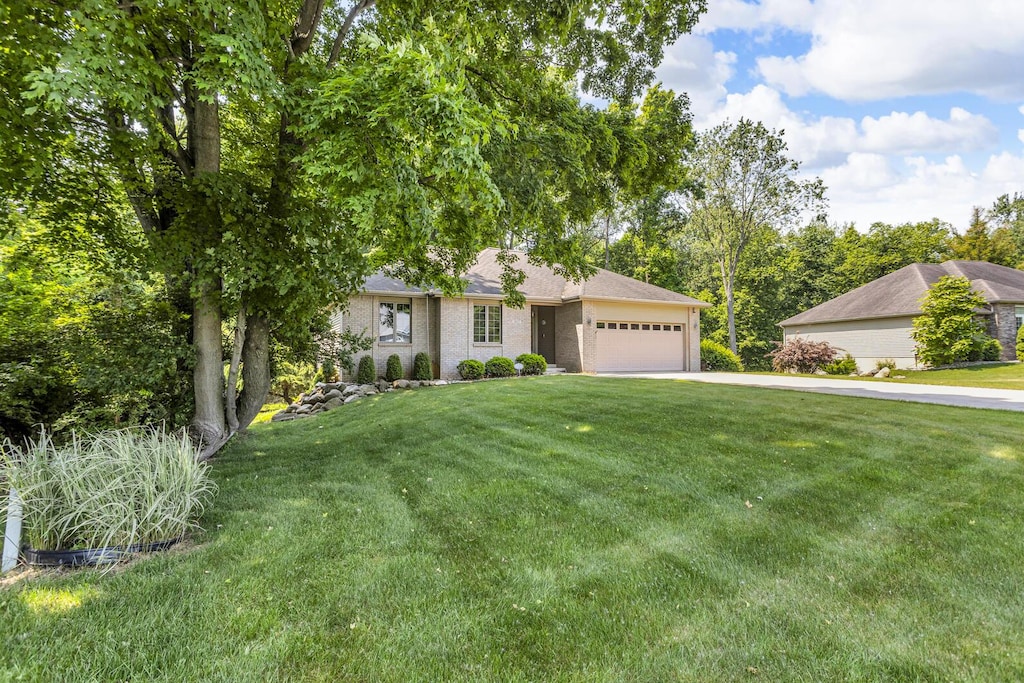 1817 Wandering Creek Dr, Jackson, MI 49201 - view of front of home with an attached garage, driveway, and a front yard